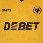 Yellow sports jersey featuring the Wolverhampton Wanderers crest on the right and the sponsor name 'DEBET' across the front, with a small 'SUDU' logo on the left.