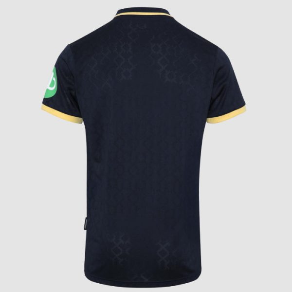 Navy polo-style jersey shown from the back with yellow trim on sleeves and collar, subtle geometric pattern, and a green circular logo on the left sleeve.