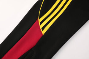 Close-up of a black garment sleeve with a red inner panel and bright yellow trim/piping.