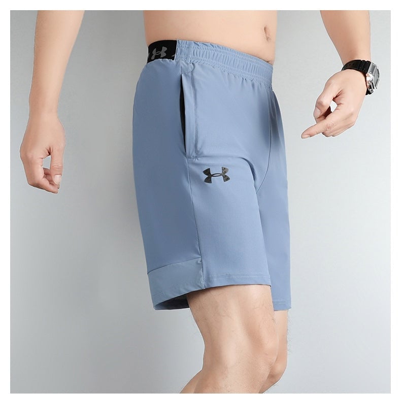 142aaebc | UAE SPORT STORE Light blue men's athletic shorts with Under Armour logo on the thigh and a side pocket.