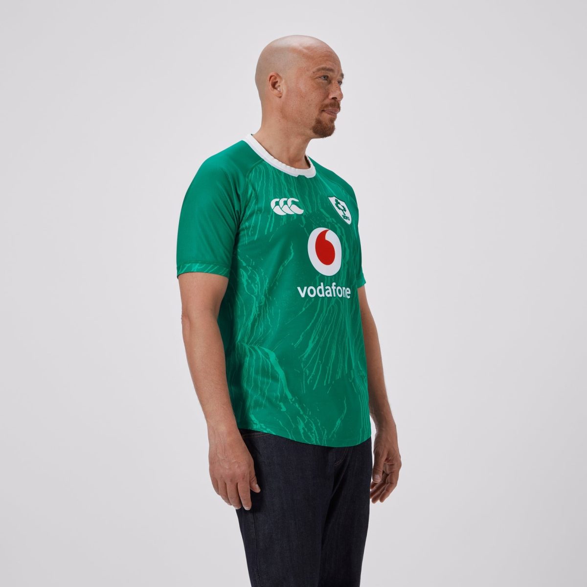 Side profile of a bald man wearing a green rugby jersey with Vodafone logo on the chest.