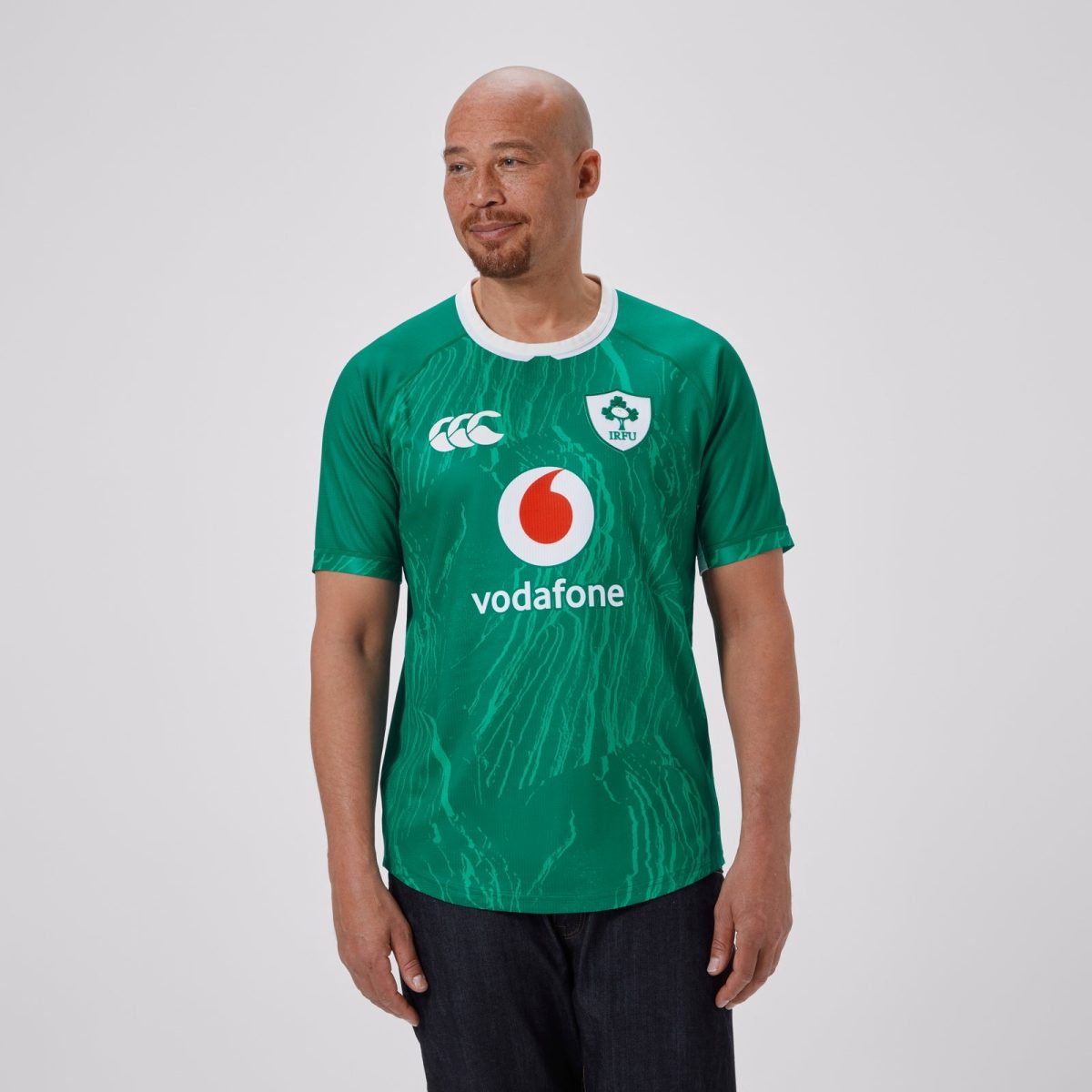 Man wearing a green Ireland rugby jersey with Vodafone sponsor, looking to the side.