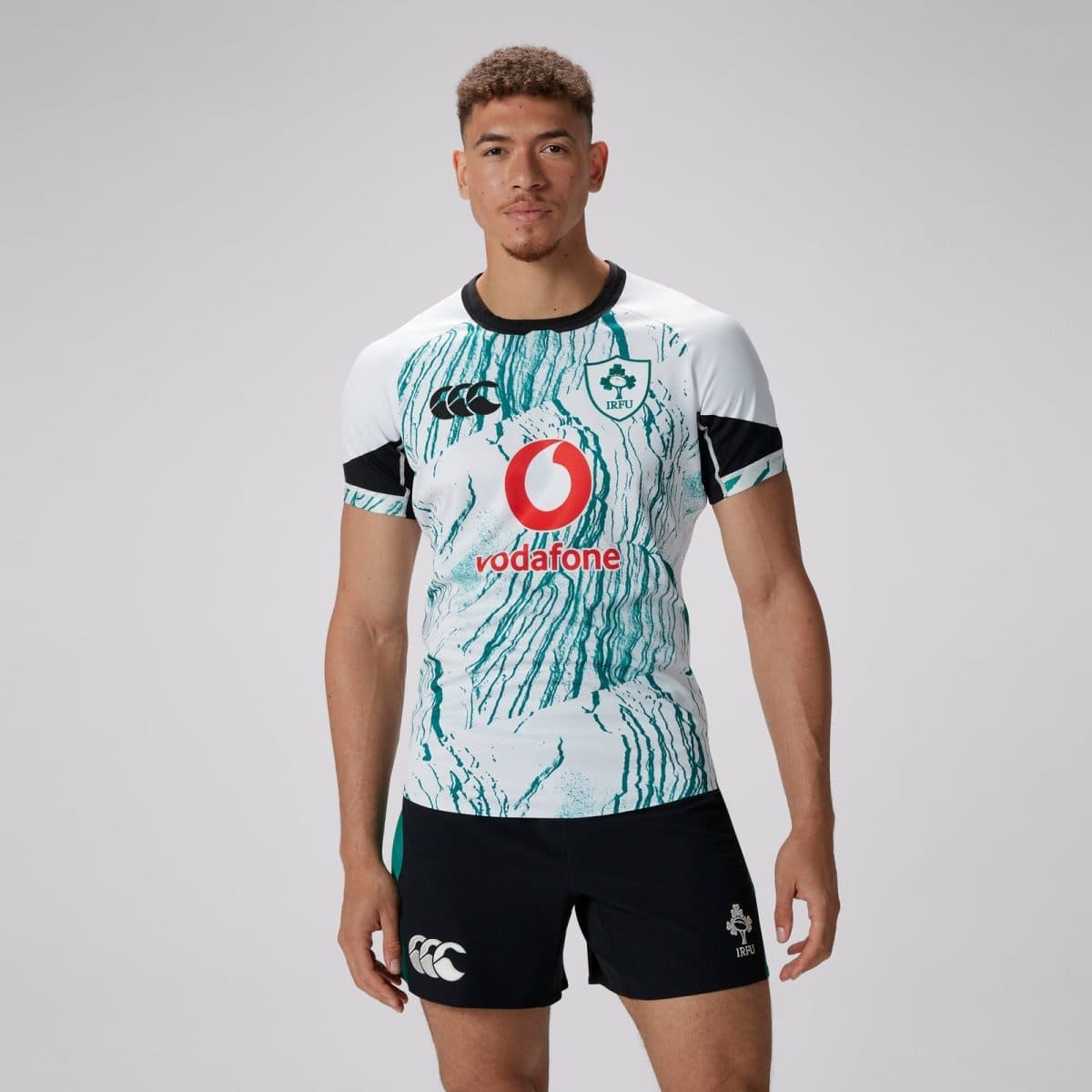 Male rugby player wearing a white teal marble-pattern jersey with Vodafone logo and IRFU crest on chest.