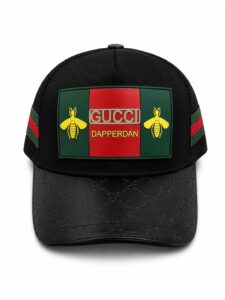 Black baseball cap with a green-red-green Gucci patch featuring yellow bees and the text 'GUCCI DAPPERDAN' on the front panel