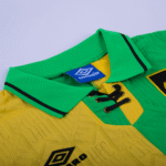 Close-up of a yellow and green Umbro soccer jersey collar with black laces and a blue brand tag.