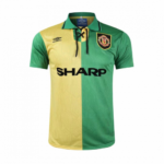 Two-tone soccer jersey with yellow left panel and green right panel, featuring SHARP sponsor and club crest on the chest, lace-up collar edge visible.