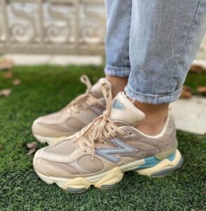 15a29329-b1d8-47c8-ae01-d81e212dd97e_6096093d-9747-4982-8d81-d7f9bca11ce2 | UAE SPORT STORE Beige chunky sneakers on a person standing on artificial grass, jeans cuffs rolled up.