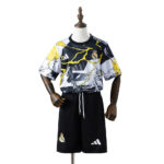Mannequin dressed in Real Madrid soccer kit: a patterned black, white, and yellow jersey with Real Madrid crest and Adidas logo, paired with black shorts featuring team crest and Adidas logo.