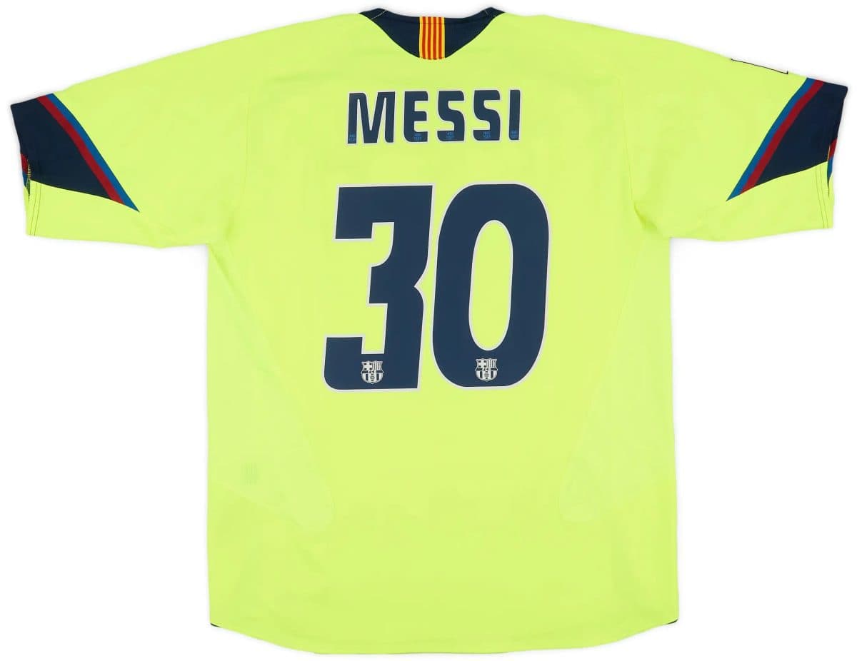 Bright neon yellow soccer jersey back: name 'MESSI' and large number 10 with small Barcelona crests at the bottom.