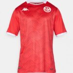Red football jersey with a pixel-like pattern, white collar trim, a white Kappa logo on the chest, and the Tunisian Football Federation crest on the left.
