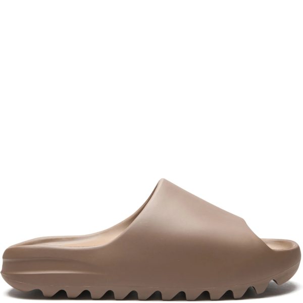 Beige women's flat shoe with a sculpted, wavy outsole edge visible from the side angle.