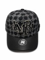 Stylish black monogram cap featuring embroidered "AMIRI" logo and abstract pattern, perfect for spor.