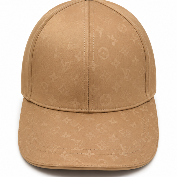 Tan baseball cap featuring a subtle Louis Vuitton monogram print and a button on top, worn-panel crown and curved brim.