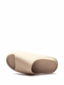 Beige prosthetic foot shell viewed from the side, showing a curved, hollowed underside and toe area designed to fit a residual limb.