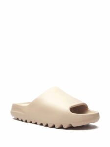 Beige slip-on clog-style shoe with a chunky sole on a white background, shown from a side perspective at the toe area.