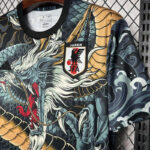 Dragon-pattern Adidas jacket with a Japan Football Association (JFA) crest on the chest; teal, gold, and black design visible.