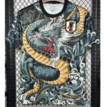 Dragon-print soccer jersey with gold scales, hanging on a metal display rack, Japan Football Association badge visible on chest