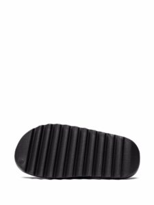 Close-up of a black rubber sandal strap with vertical ridges on a white background