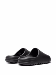 Pair of black slide sandals on a white background with textured soles.