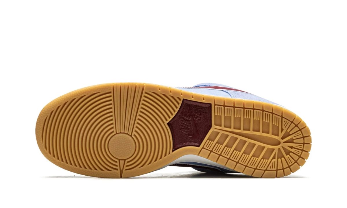 Bottom view of a sneaker outsole with tan rubber and concentric circle tread patterns at the toe and heel area.