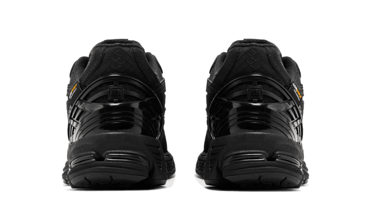 Back view of two black sneakers side by side on a white background .