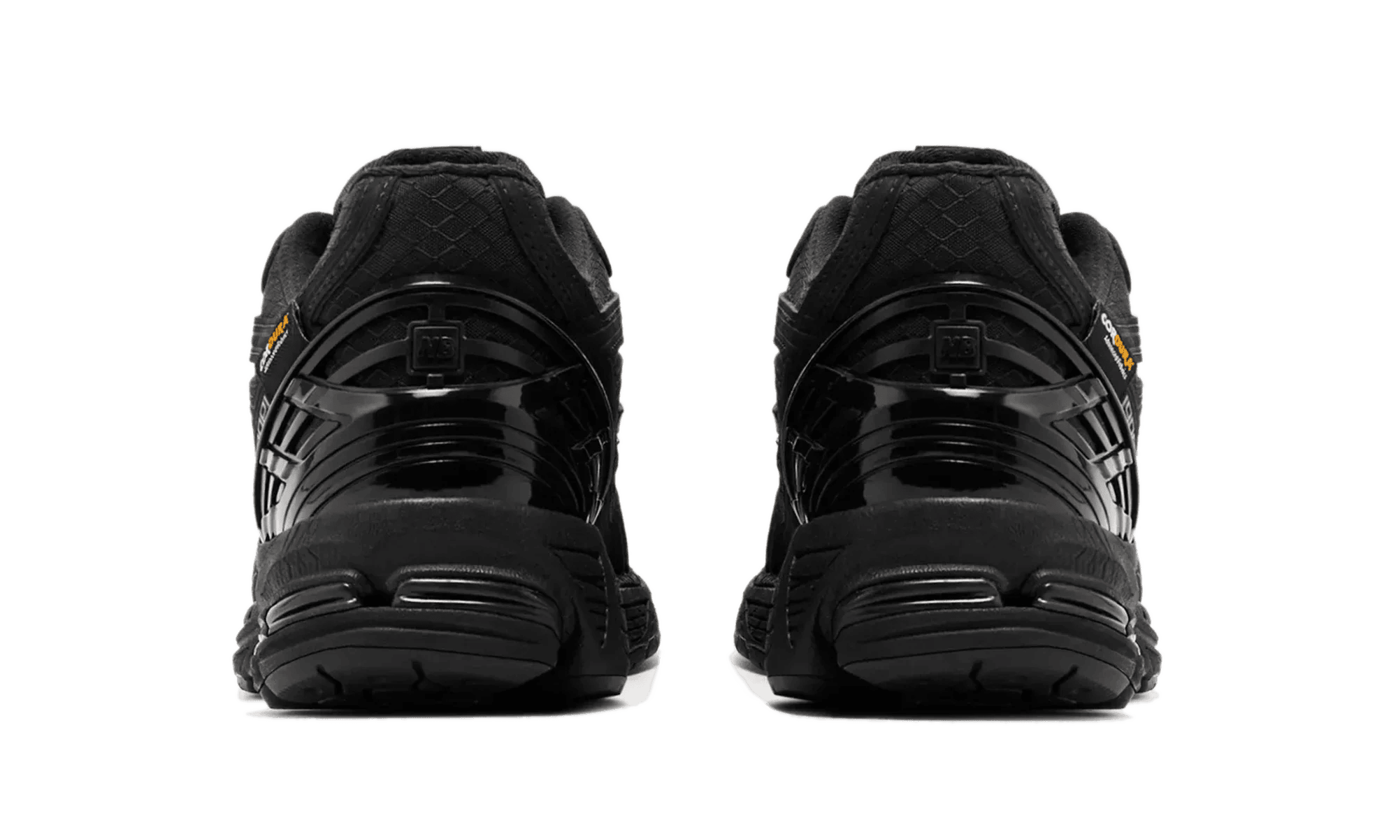 1906d-protection-pack-triple-black-m1906df-2 | UAE SPORT STORE Back view of two black sneakers side by side on a white background .