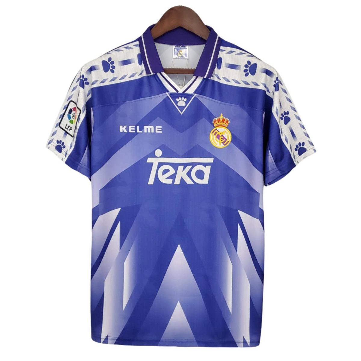 Blue Real Madrid football jersey on a hanger, featuring TEKA sponsor and club crest.