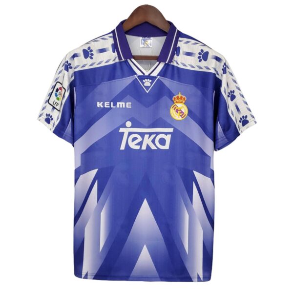 Blue Real Madrid football jersey on a hanger, featuring TEKA sponsor and club crest.