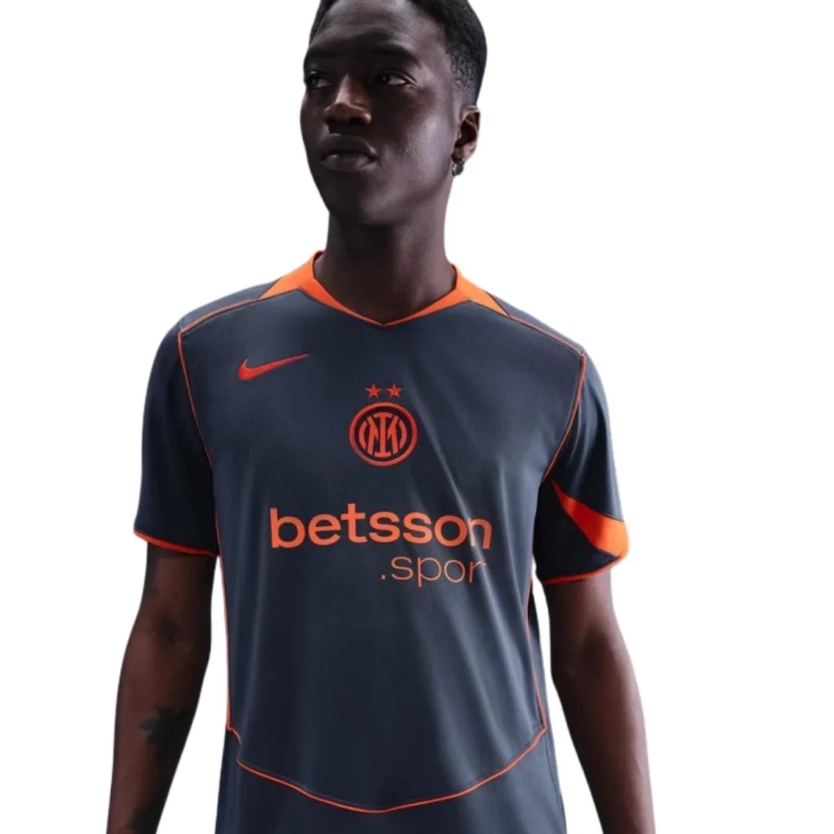 Athlete wearing a dark blue soccer jersey with orange trim and sponsor 'betsson' across the chest.