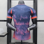 19bd88d8 | UAE SPORT STORE Back view of a tie-dye purple and pink athletic shirt with orange trim on sleeves, displayed on a mannequin in a rack.