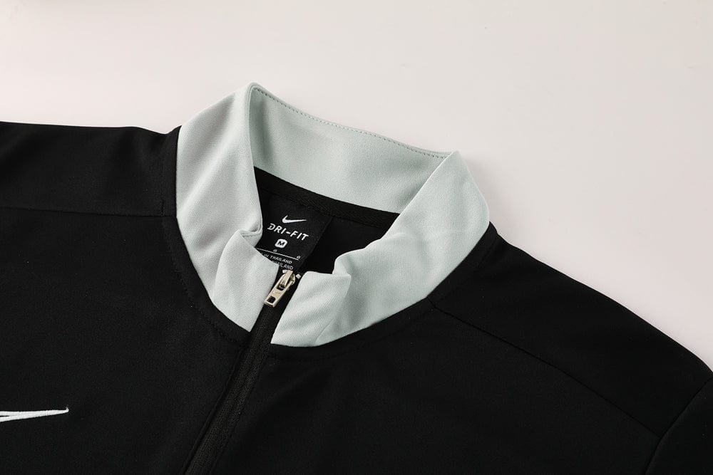 19bdf453 | UAE SPORT STORE Close-up of a black Nike Dri-FIT athletic jacket with a light gray collar and front zipper.