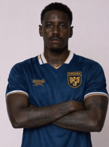 Man with arms crossed wearing a blue Panama national football jersey, facing the camera