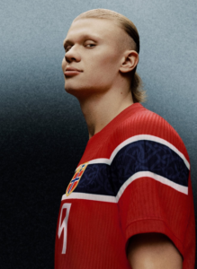 Athlete in a red jersey with white and blue stripes, shoulder turned toward the camera, number 7 visible on the chest area.