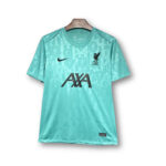 Teal Liverpool FC away jersey on a wooden hanger with Nike swoosh, LFC crest, and AXA sponsor on the front.