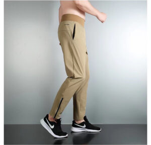 Tan cargo jogger pants with zip vents at the calves, shown in a side view paired with black Nike sneakers.