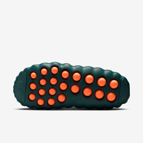 Teal sneaker outsole featuring orange circular studs arranged in rows across the bottom surface.