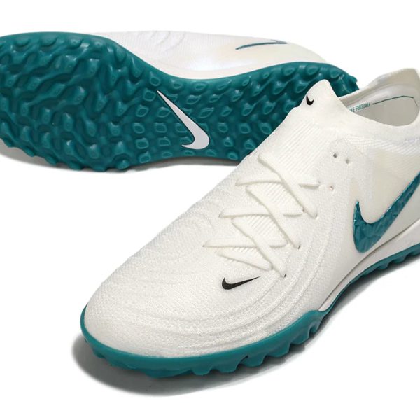 White athletic shoe with a teal sole and teal Nike swoosh, shown at an angle to highlight the tread.