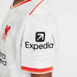 White Liverpool FC jersey sleeve featuring the Expedia sponsor logo on the upper arm with red trim at the edge.