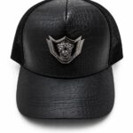 Black leather-look crown cap with lion emblem.