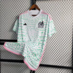 White soccer jersey with mint green abstract pattern and pink trim hanging on a hanger against a chain-link fence; Adidas logo on right chest and a winged-creature crest on left chest