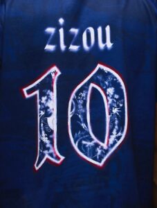 Dark blue jersey with the name 'zizou' and a large number 10 outlined in white and red with a floral fill (front view).