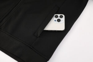 White smartphone sticking out of the back pocket of a black jacket or pants.