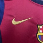 Close-up of maroon athletic jersey fabric featuring a gold Nike swoosh with blue and yellow trim nearby.