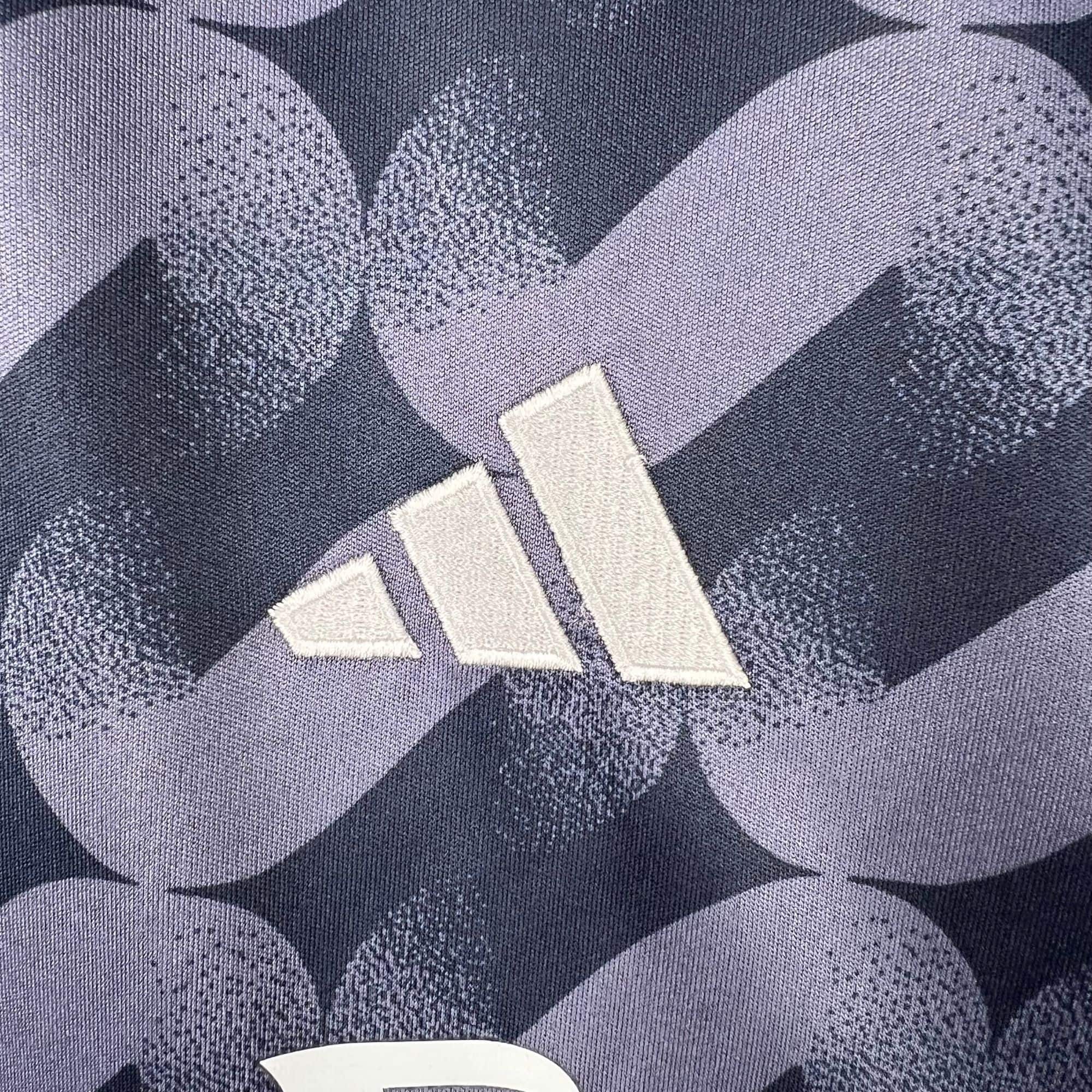 1df5b529 | UAE SPORT STORE Close-up of dark blue denim fabric with a geometric chevron pattern in lighter and darker blues, and a white curved edge fragment at the bottom center.