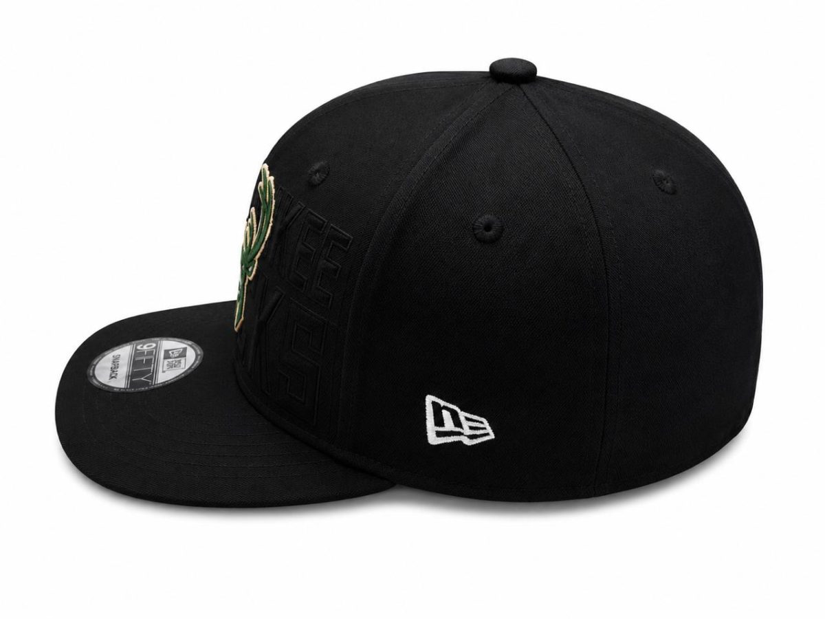 Black fitted baseball cap with a green embroidered leaf patch on the side and a white New Era logo on the back edge of the cap, shown from a three-quarter angle.