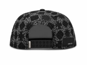 1f59dc5a-978a-4739-b53a-4c0e506af8fa | UAE SPORT STORE Back view of a black-and-white patterned snapback hat with an adjustable plastic strap and an AMIRI label patch on the side.