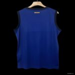 Back view of a royal blue sleeveless sports jersey on a wooden hanger, dark trim along the armholes and neckline.