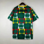 Back view of a Senegal football jersey on a hanger, featuring a green geometric pattern in red, yellow, and white, with 'SENEGAL' across the upper back.