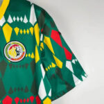 Close-up of a green geometric-patterned sports jersey with a circular Senegal Football Federation crest on the chest.