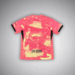 Pink athletic jersey with black-trimmed sleeves, featuring a pink-to-cream tie-dye pattern and the UNHCR ACNUR logo near the bottom back.